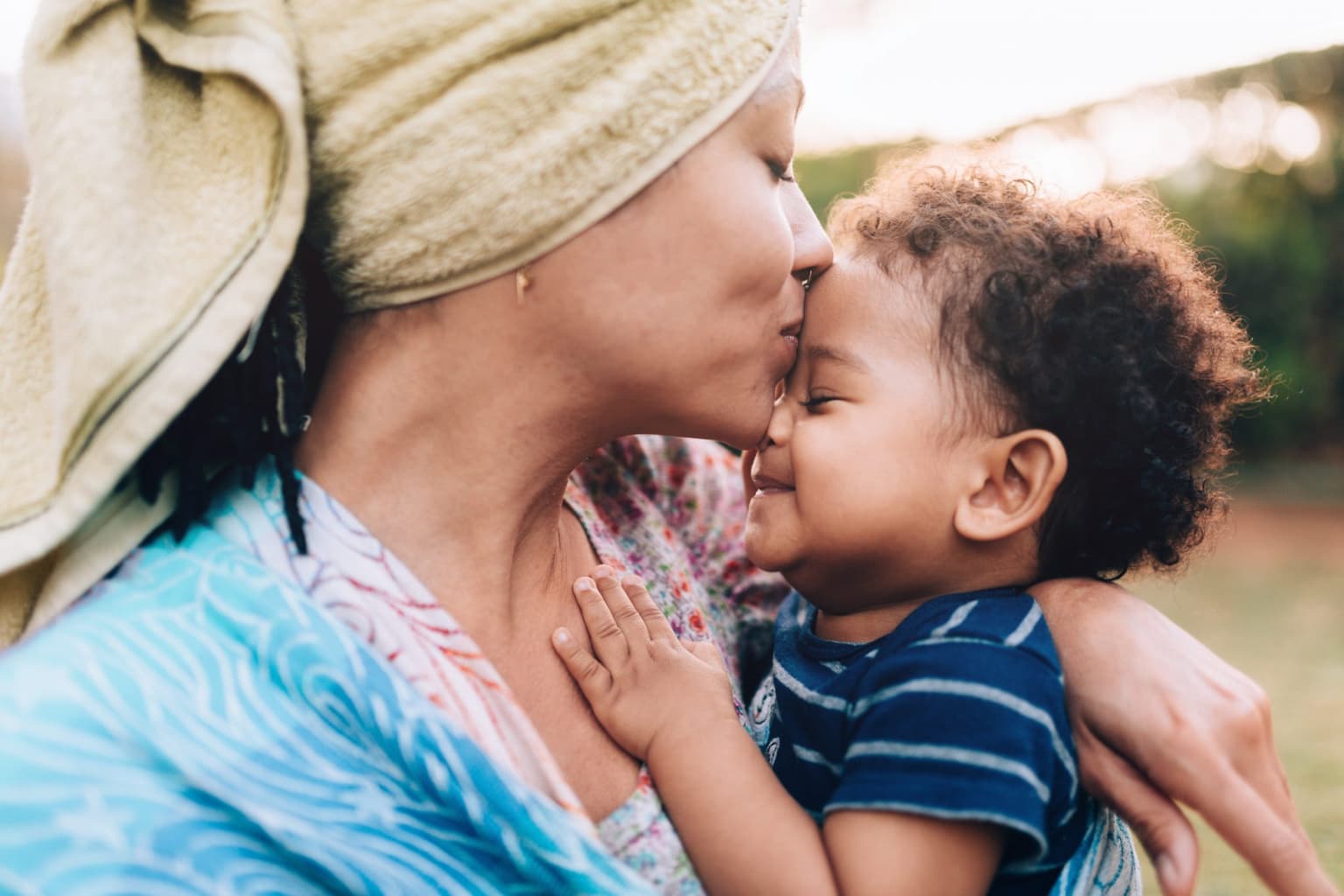 Mum kissing baby's forehead