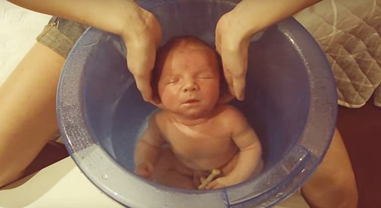 Newborn Baby Enjoys First Bath in the Tummy Tub Newborn Baby Enjoys First Bath in the Tummy Tub