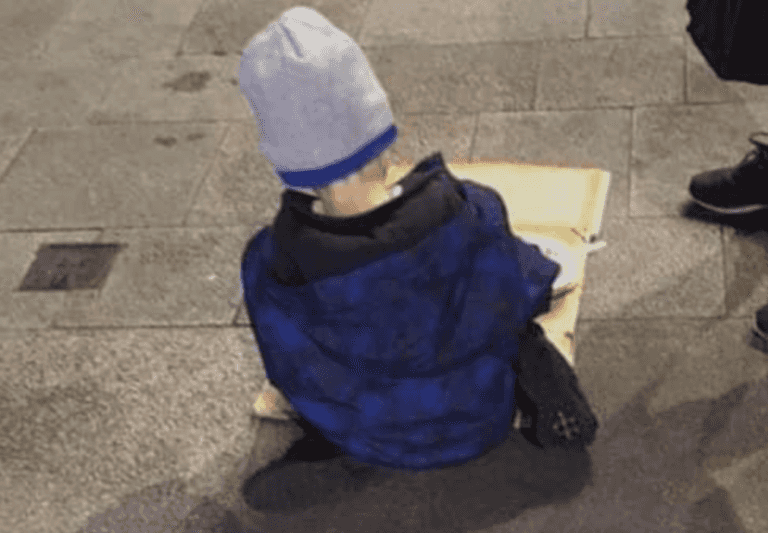Five-year-old boy eating dinner from a sheet of cardboard shows reality of the homeless crisis Five-year-old boy eating dinner from a sheet of cardboard shows reality of the homeless crisis